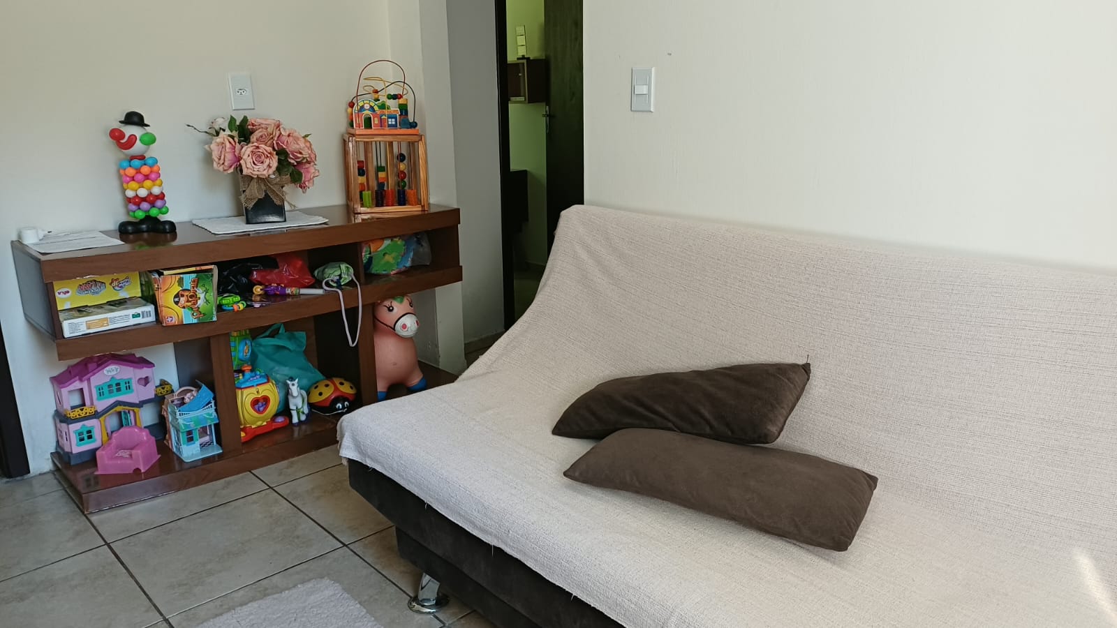 Sofá-cama e brinquedos infantis na sala do Espaço Família